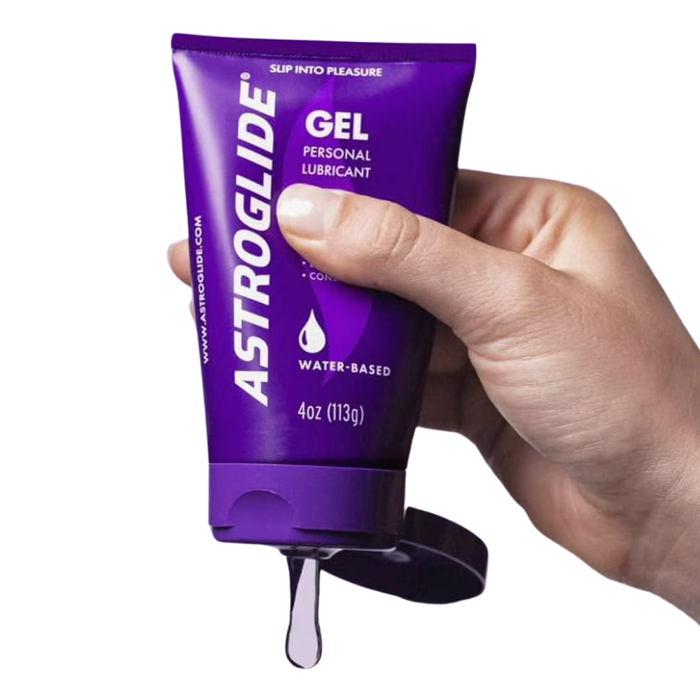 Hand squeezing a tube of Astroglide Gel water-based personal lubricant with gel dripping out on a white background